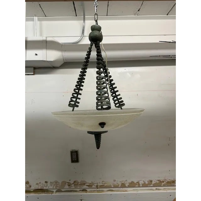 This is a very unique pendant light made in Italy of patina'd iron and scavo glass bowl. The 3 arms have a ringlet detail...