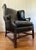 Vintage black leather Georgian style rolled arm wingback chair with rolled arms and brass tacks