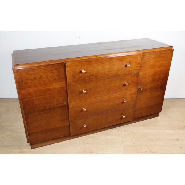 A superb Art Deco sideboard dating from the 1940s/1950s, crafted from varnished rosewood in warm, deep tones, revealing an...