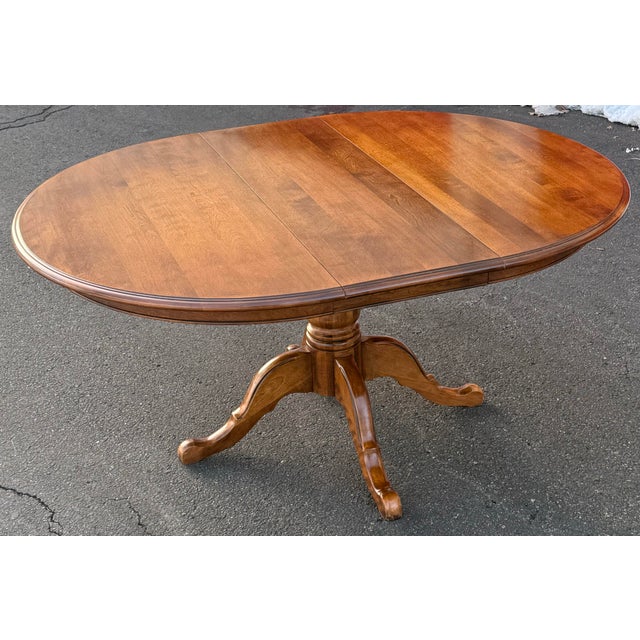 Beautiful Ethan Allen pedestal dining table features warm, rich wood finish and traditional design. Crafted from durable...