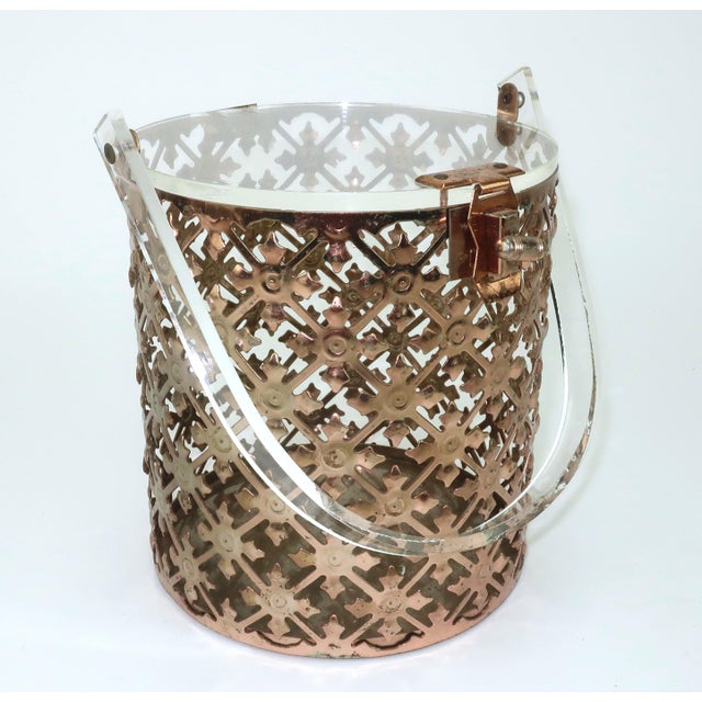 1950's pierced filigree metal handbag with a copper finish and lucite top and handle. The unique cylinder silhouette is a...