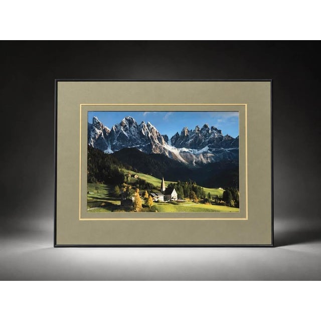 Elegant framed landscape photograph featuring a scenic Dolomites mountain range with snow-capped peaks, a lush green...