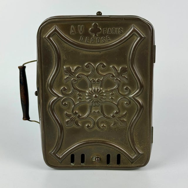 An antique French metal portable Chaufferette coal box with wooden handle. It was used while tatting* to warm the hands....