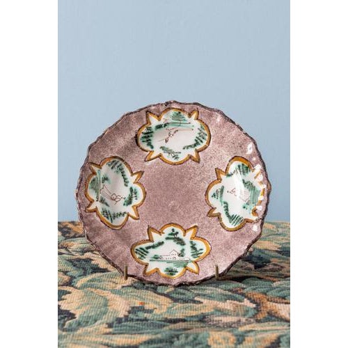 A pair of 18th-century Belgian faience plates from Brussels. Each plate is decorated with four foliate-shaped reserves...