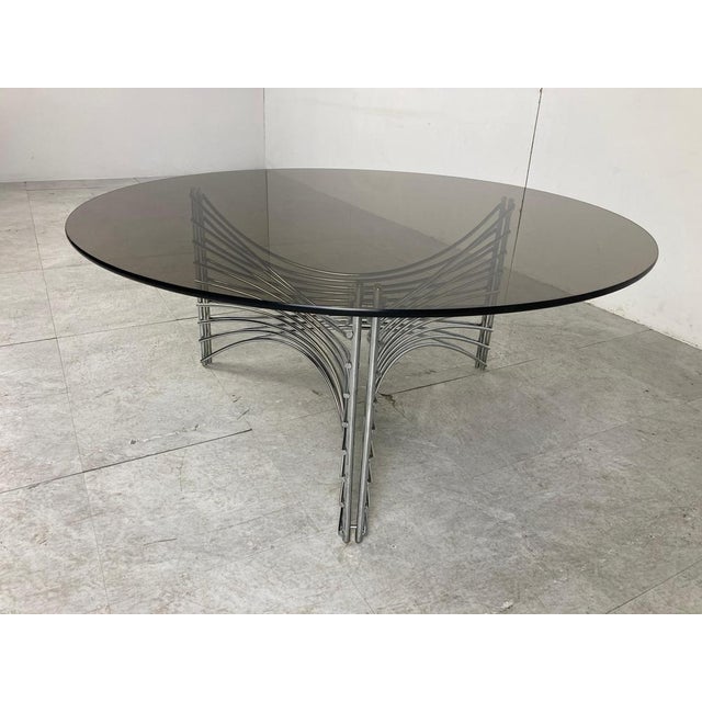 Space age era coffee table with a chromed metal wire base and a round smoked glass top. 1970s - Germany. Good condition....