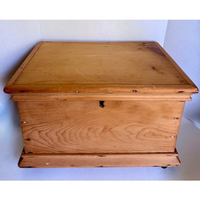 This charming antique pine storage trunk dates to the late 19th or early 20th century and features wonderfully simple...