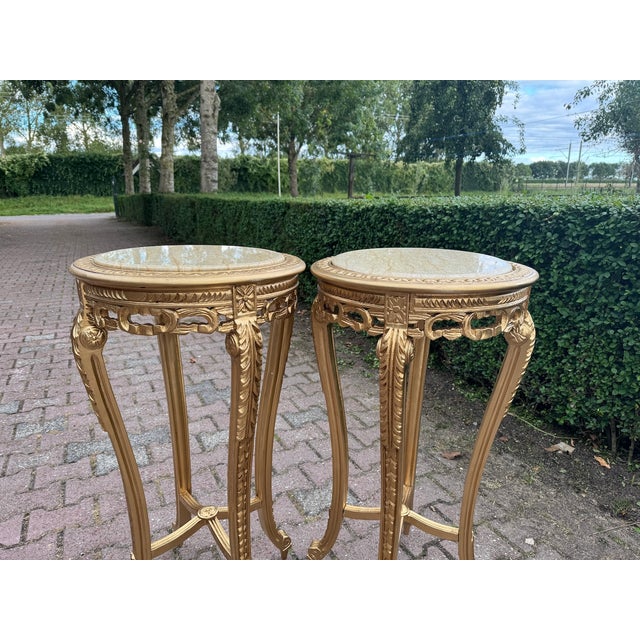 Bring timeless French elegance into your interior with this refined pair of Louis XVI-style side tables, crafted in France...
