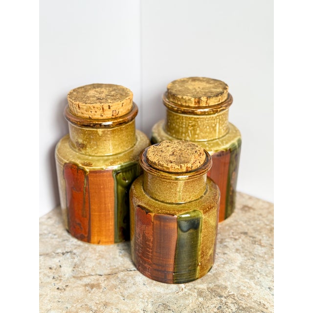 Elevate your home with the timeless beauty of this set of three vintage Japanese ceramic kitchen canisters from the 1970s....