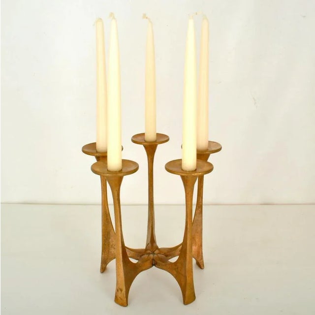 Bronze cast candelabra composed of five radiating cast-bronze arms with saucer shaped candle holders. It is designed by...