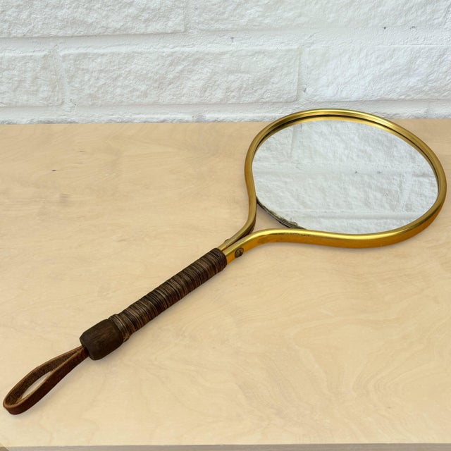 Scandinavian handheld vanity mirror produced in Sweden in the 1950s. Executed in a bent brass frame with an organic,...