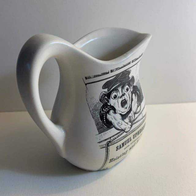 Charming small white ceramic creamer with advertising printed in it.