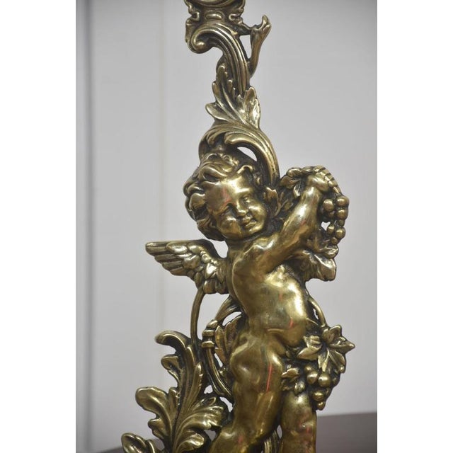 A decorative pair of solid brass door stops cast as winged putti in the Rococo taste. Each cherub is shown in animated...