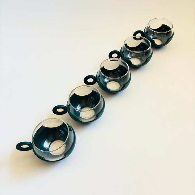 A set of 5 mid century mugs. Each is made of glass that snaps into a dark teal plastic base. Great mid century design with...