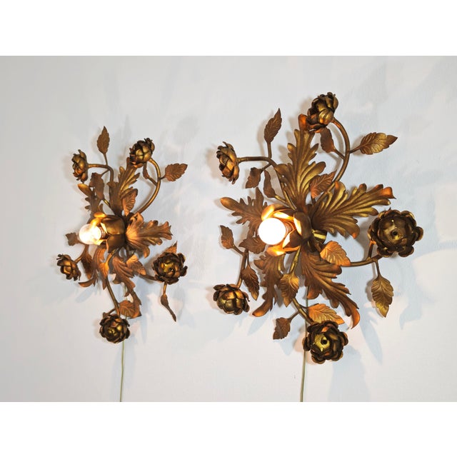 Stunning pair of vintage Florentine wall or ceiling lamps, handcrafted in gilded wrought iron with floral motifs. The...