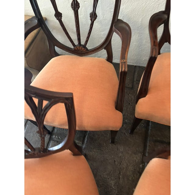 This is a set of 4 vintage mahogany shield back chairs with reupholstered seats. Two of the chairs are arm chairs. The...