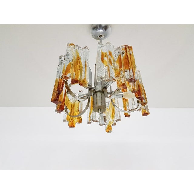 Heavy Murano Chandelier, Italy 1970’s Beautiful metal chandelier with heavy amber colored Murano glass elements. Total...