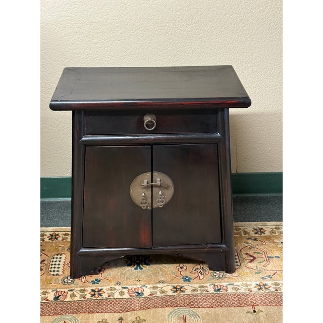 Design Plus Gallery presents a Lacquered Nightstand with Chinese Influence. The bedside table is black with a bit of red...