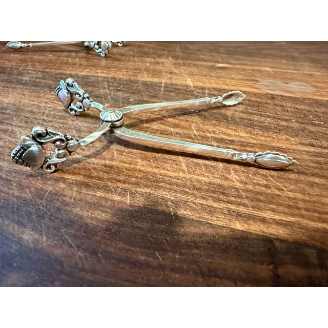 A pair of sterling silver sugar tongs. Designed in 1915 by Johan Rohde, the Acorn sterling silver cutlery pattern...