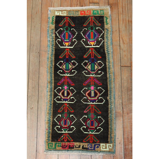 A late 20th century mini size turkish rug with a tribal motif. This piece is a true vintage, one of a kind rug that has...