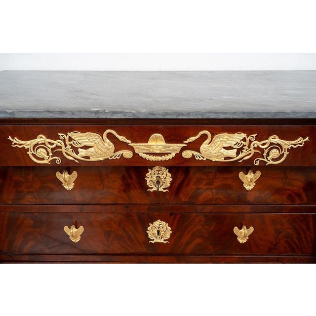 An antique Empire-style chest of drawers in mahogany veneer with a Bardiglio gray marble top, dating from the early 19th...