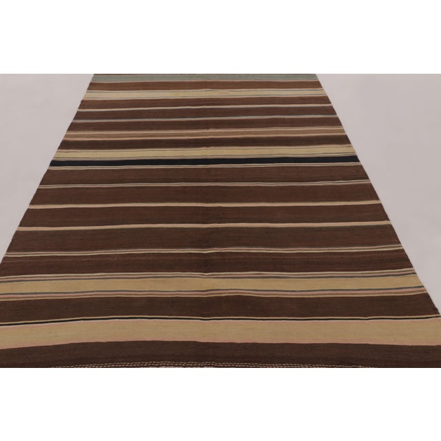 Made with handwoven wool circa 1950-1960, this 6x9 vintage flat-weave Kilim is a particularly grounding and sought-after...