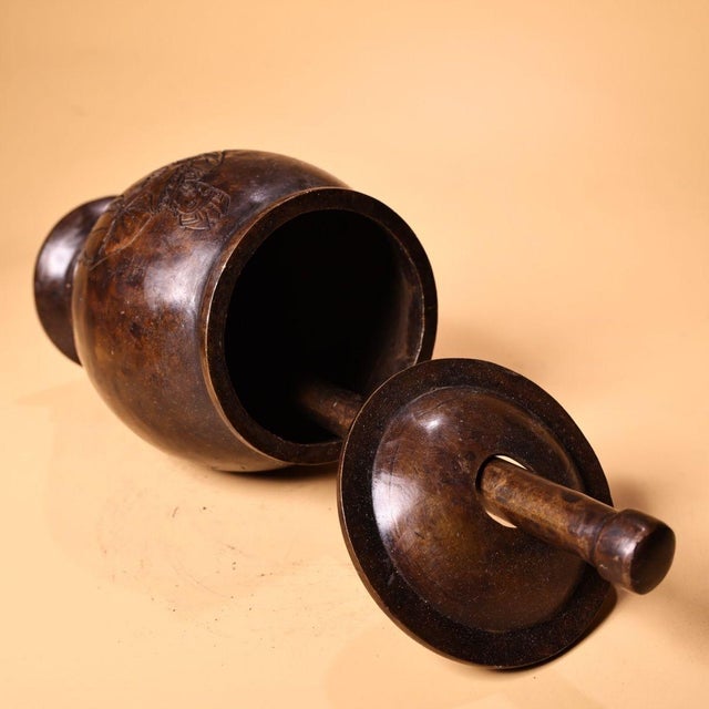 This is a substantial antique bronze mortar and pestle, a traditional apothecary tool used for grinding herbs and...