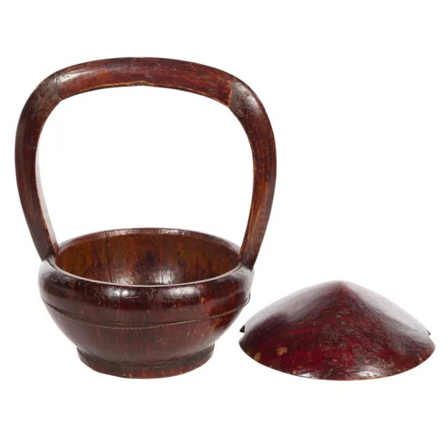 Antique Chinese wooden covered basket with a handle used for the storage and transport of food. Two metal bands Hold the...