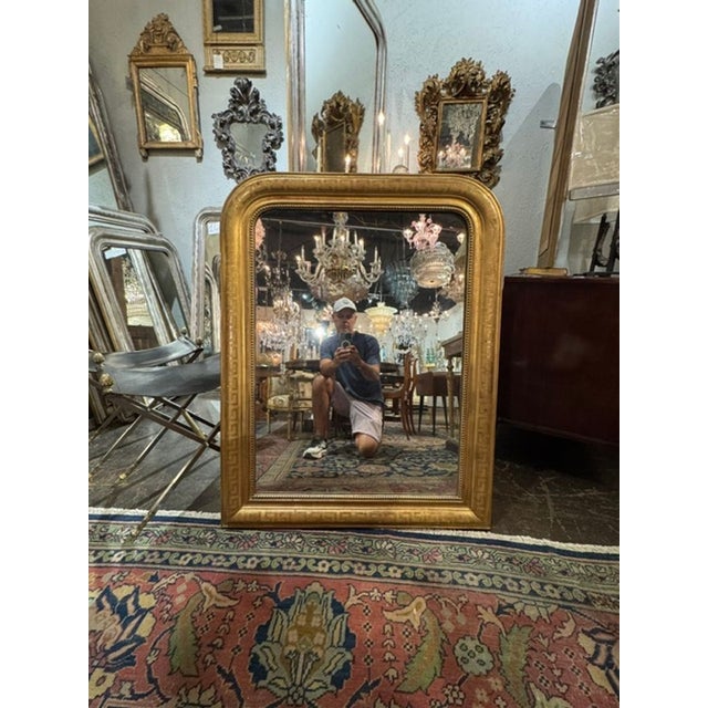 The product is a fine 19th century French Louis Philippe mirror with a Greek key frame, adding a touch of elegance to any...