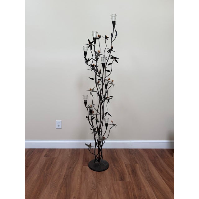 Monumental vintage floor candelabra in wrought iron with a sculptural botanical branch-and-leaf motif, accented by amber...