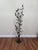 Monumental vintage floor candelabra in wrought iron with a sculptural botanical branch-and-leaf motif, accented by amber...
