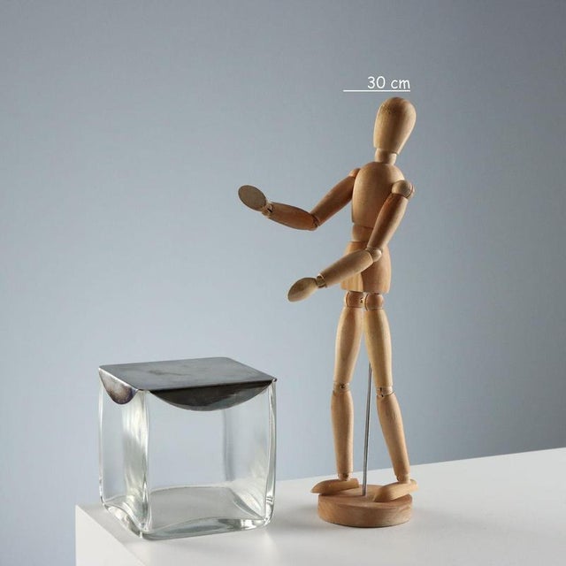 Clear glass cube-shaped box with a metal lid. Lino Sabattini branding engraved inside the lid. This piece is attributed to...