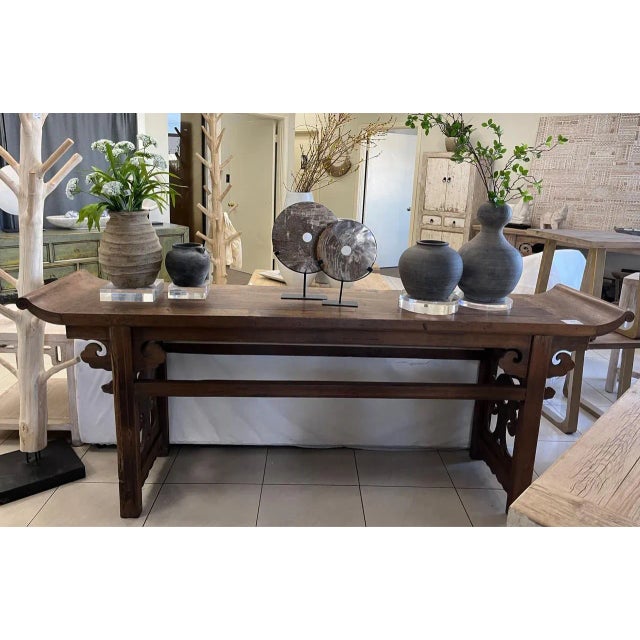 Hand-shaped and sanded smooth, this console table shows off walnut in natural wood, its surface carrying the quiet...