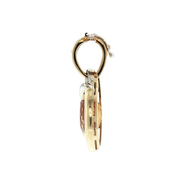 An elegant late 20th-century pendant featuring an oval-cut orange citrine as the centerpiece. The citrine is encased in...