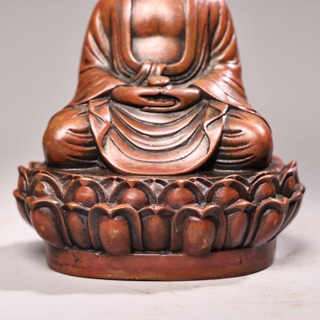 This finely crafted copper statue depicts Shakyamuni Buddha seated in meditation pose upon a detailed lotus pedestal....