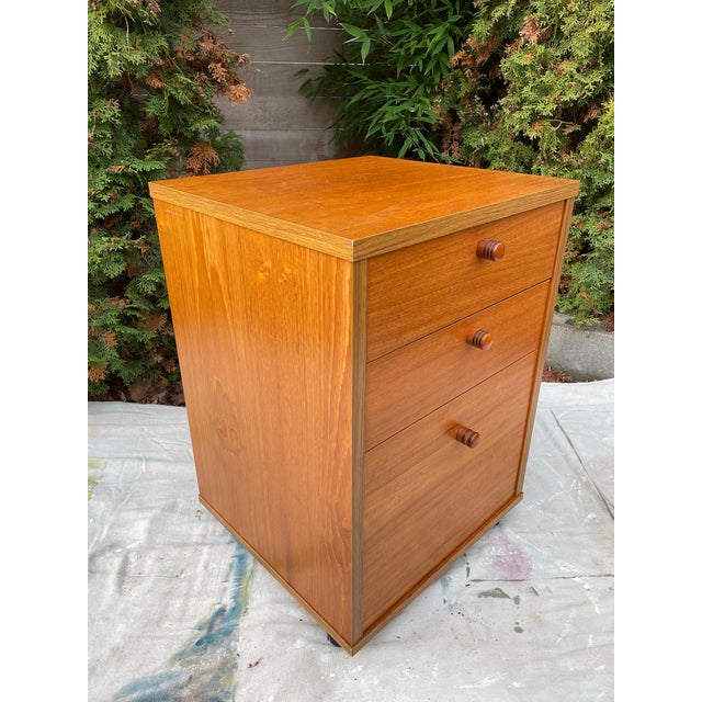 A heavy and solidly built Mid-Century Danish Modern teak filing cabinet with three drawers, the lower drawer with file...