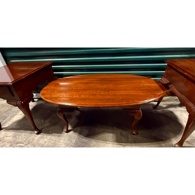 This elegant furniture grouping consists of one oval coffee table and two matching end tables, characterized by their...