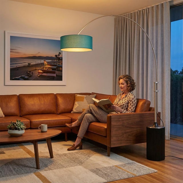 The Tambo Arc Lamp is a Mid-Century Modern floor lamp designed by Peter Morelli in 1984, featuring a satin nickel finish...