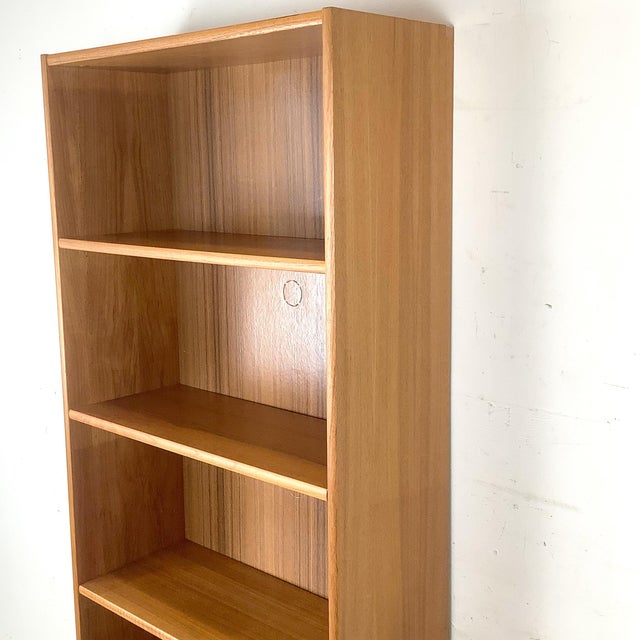 Classic Scandinavian Modern open bookcase crafted in warm teak veneer, featuring five spacious fixed shelves within a...
