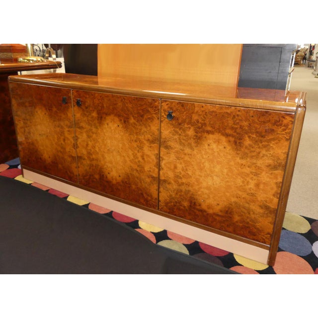 Vintage Roche Bobois lacquered burl wood credenza. Features 3 doors with 8 concealed drawers and shelves at the center....