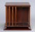 Edwardian mahogany four-sided revolving desk book stand with slatted sides, raised on a square base.