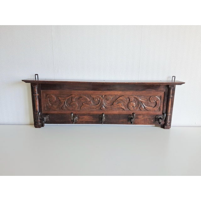 Decorative wall-mounted coat rack, suggest oak or similar hardwood, dating to the early 20th century, circa 1890–1925. The...