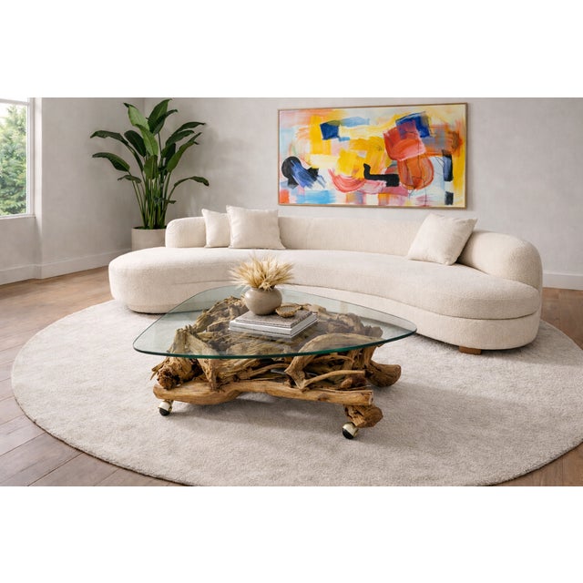 Organic Mid Century Modern coffee table featuring a dramatic sculptural base crafted from intertwined natural driftwood...