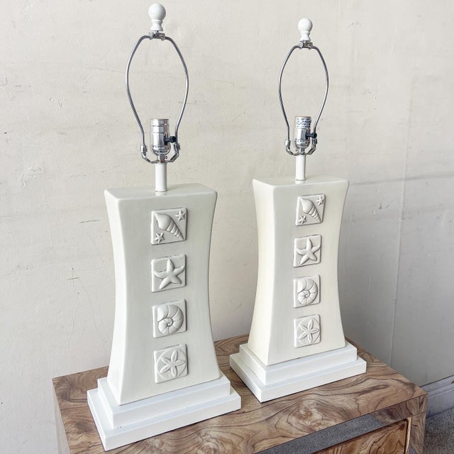 Amazing pair of coastal ceramic table lamps. each feature a sea shell, sea snail, star fish and sand dollar on each side.