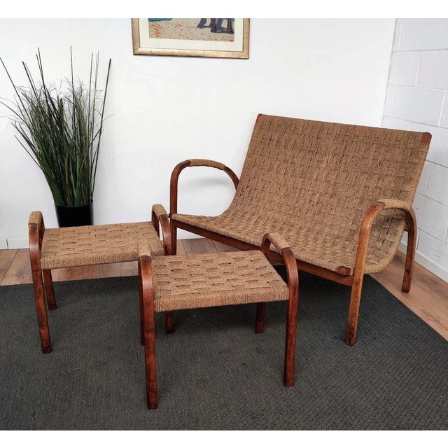 Stylish 19060s Mid-Century Modern lounge bench armchair in wood and cord or woven rope, in the style of Audoux Minet. The...