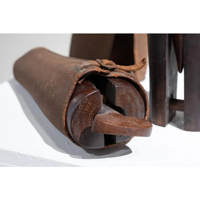 Pair of antique wooden boot trees with their original leather and burlap covers. They consist of a wooden tourniquet that...