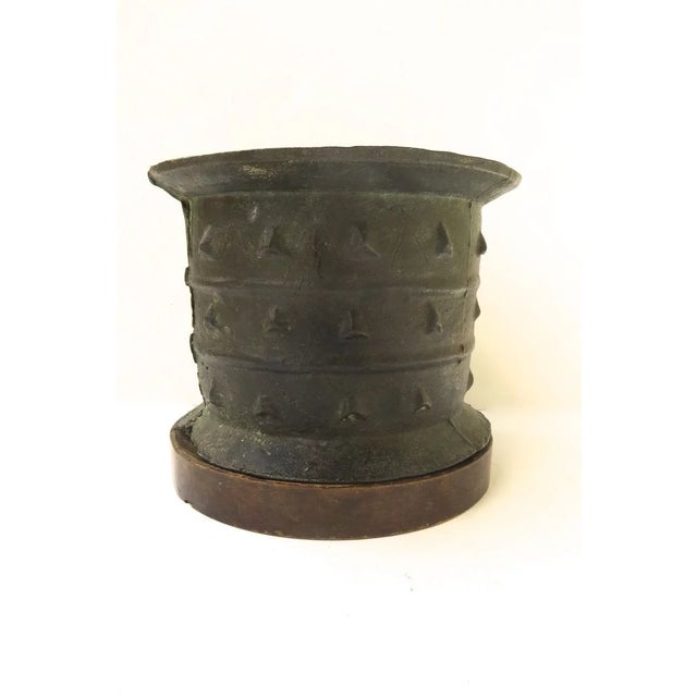 Impressive large cylindrical bronze mortar with flared rim. Body decorated with three arrays of triangular motif and two...