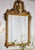 Hand crafted in Italy from solid beech wood, this wall mirror features a hand-carved frame finished in 24-karat gold leaf....