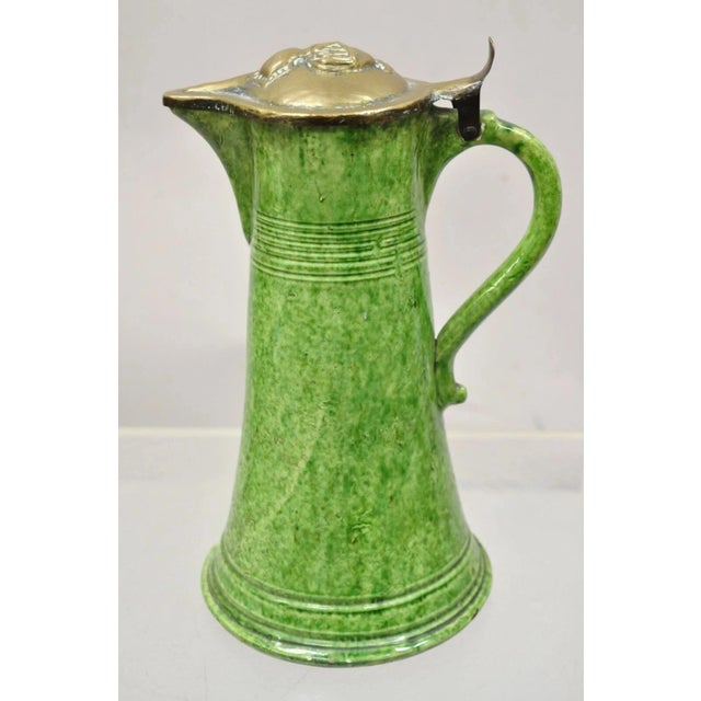 Antique Gothic Renaissance Green Ceramic Pitcher with Brass Soldier Armor Lid. Circa Late 19th Century. Measurements: 12"...