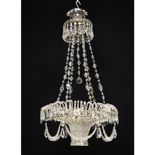 Of elegant basket form festooned with crystal garlands and hanging from a chains beaded with varying sized crystal beads,...