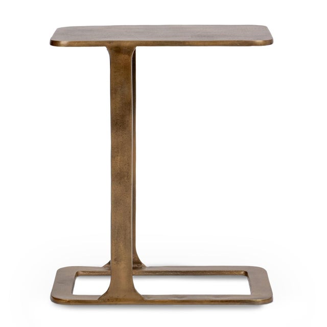 Modern cast aluminum end table with a warm antiqued brass finish. Its sculptural cantilever silhouette offers a refined...